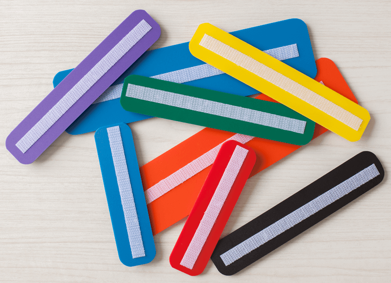 Bande Phrase supplémentaire Ensemble de bandes colorées, appellées bandes texte, comportant une bande réfléchissante, posées sur une surface claire.